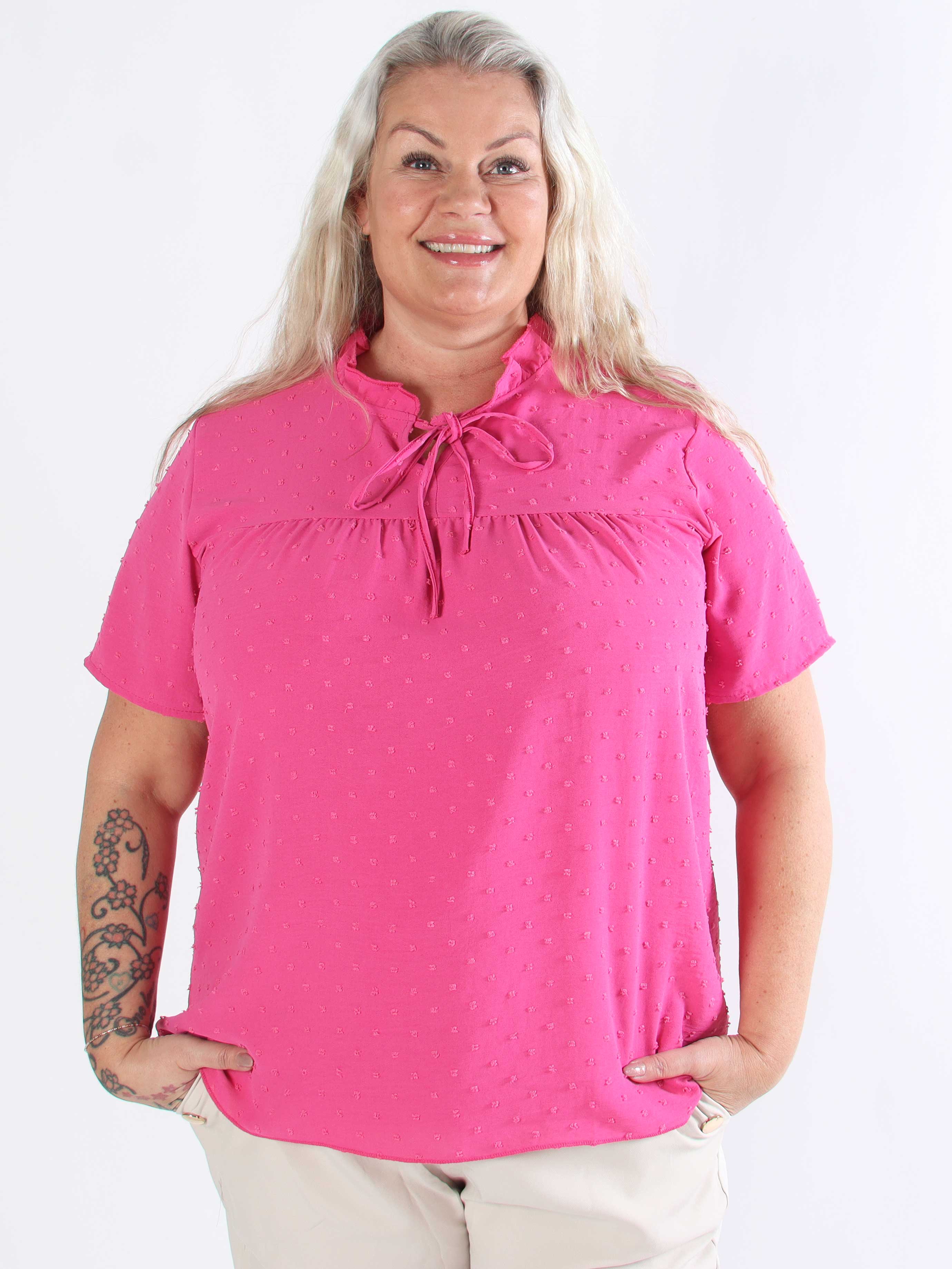 Bloom - Söt tunika i plusstorlek med volangkant och rosett